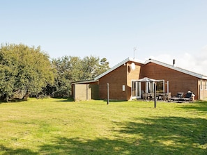 A wooden cabin with a covered patio area, a small shed, and a grassy yard. - 6 Person Holiday Home in Asnaes-by Traum (Asnaes)