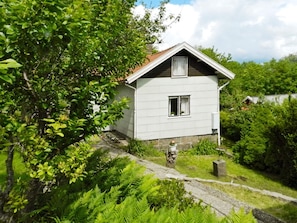 A single-story house with a sloped roof, a small window, and a door. - 6 Person Holiday Home in Brastad (Brastad)