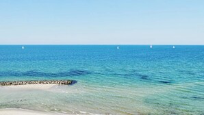 A clear view of the ocean with a rocky shoreline and sailboats in the distance. - 5 Star Holiday Home in Frederiksvaerk (Frederiksvaerk)