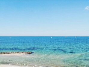 A clear view of the ocean with a rocky shoreline and sailboats in the distance. - 5 Star Holiday Home in Frederiksvaerk (Frederiksvaerk)