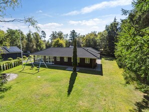 A residential property with a house, a swing set, and a well-maintained lawn. - 5 Star Holiday Home in Frederiksvaerk (Frederiksvaerk)