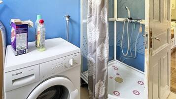 A compact laundry area with a Bosch washing machine, a shower with a floral shower curtain, and a door leading to another room.