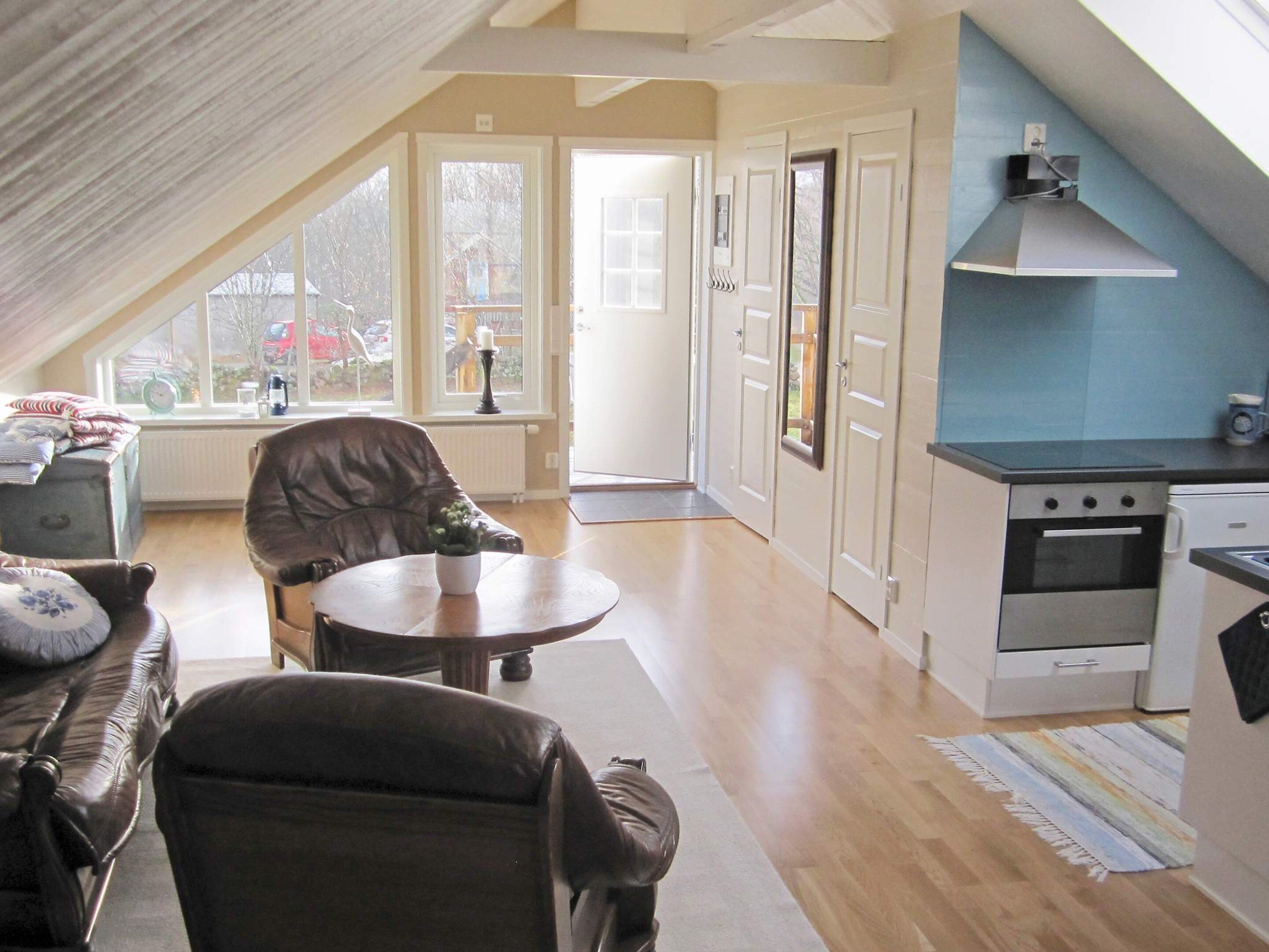 A cozy living room with a fireplace, a dining area, and a kitchen with modern appliances.