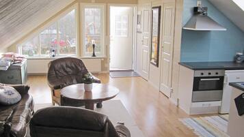 A cozy living room with a fireplace, a dining area, and a kitchen with modern appliances.