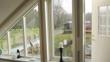 A room with large windows, a radiator, and a candle on the windowsill.