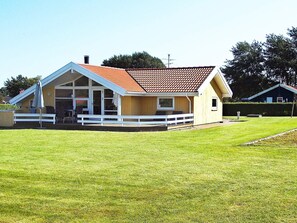 A single-story house with a sloped roof, a covered porch, and a fenced yard. - 6 Person Holiday Home in Nordborg-by Traum (Nordborg)