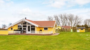 A yellow house with a red roof, a deck, and a grassy yard. - 6 Person Holiday Home in Nordborg-by Traum (Nordborg)