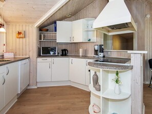 A compact kitchen with white cabinets, a microwave, a coffee maker, and a small shelf with decorative items. - 6 Person Holiday Home in Nordborg-by Traum (Nordborg)