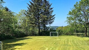 A well-maintained grassy area with a soccer goal, surrounded by trees and a clear sky. - 8 Person Holiday Home in Roslev-by Traum (Roslev)
