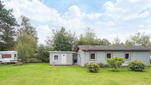 A small, single-story mobile home with a red roof and white siding, surrounded by a grassy yard and trees. - 6 Person Holiday Home in Eskebjerg-by Traum (Eskebjerg)