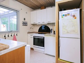 A kitchen with white cabinets, a stove, oven, and a refrigerator with magnets. - 6 Person Holiday Home in Eskebjerg-by Traum (Eskebjerg)