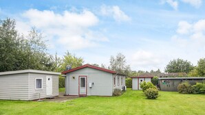 A row of small, single-story mobile homes with red trim and a grassy yard. - 6 Person Holiday Home in Eskebjerg-by Traum (Eskebjerg)