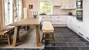 A kitchen with wooden cabinets, a large wooden table, and a bench. - 4 Star Holiday Home in Favang (Ringebu)
