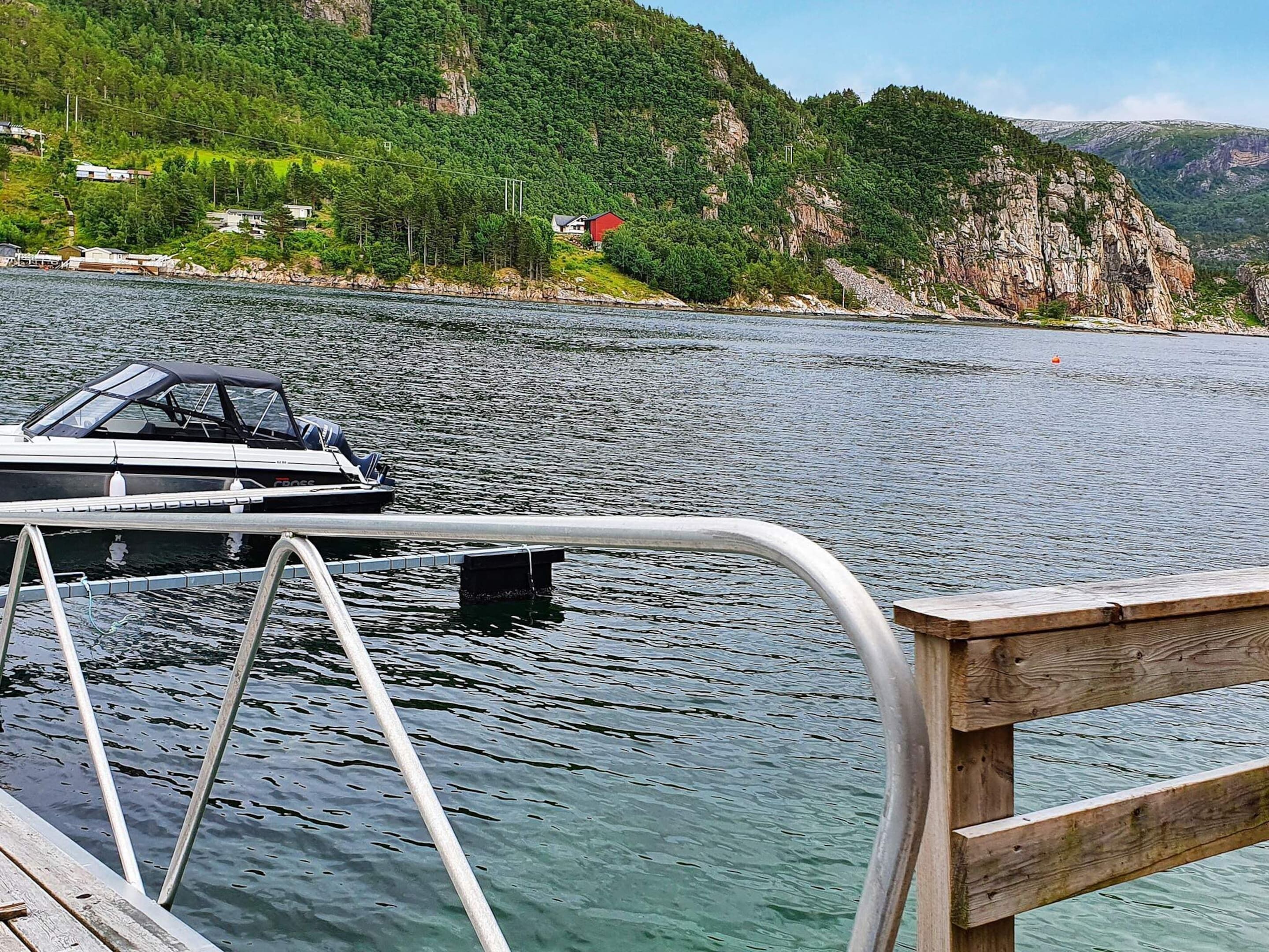 A boat docked at a pier with a view of a mountainous landscape in the background.