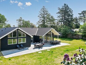 A modern house with a patio, a dining area, and a covered outdoor space. - 5 Star Holiday Home in Liseleje (Liseleje)