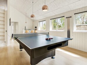 A ping pong table in a room with large windows, wooden walls, and pendant lights. - 5 Star Holiday Home in Liseleje (Liseleje)