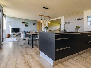A modern kitchen with a large island, built-in appliances, and pendant lighting. - 8 Person Holiday Home in Olsted-by Traum (Olsted)