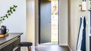 A hallway with a plant, a door leading outside, and a wall with hanging towels. - 8 Person Holiday Home in Olsted-by Traum (Olsted)