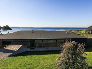 A modern building with a flat roof overlooking a body of water. - 8 Person Holiday Home in Olsted-by Traum (Olsted)