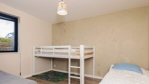 A bedroom with a bunk bed, a single bed, a window, and a hanging light fixture. - 8 Person Holiday Home in Olsted-by Traum (Olsted)