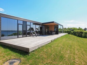 A modern house with a deck, large windows, and outdoor furniture. - 8 Person Holiday Home in Olsted-by Traum (Olsted)