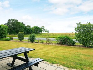 A picnic table in a grassy area with a view of a road and trees. - 5 Person Holiday Home in Roslev-by Traum (Roslev)