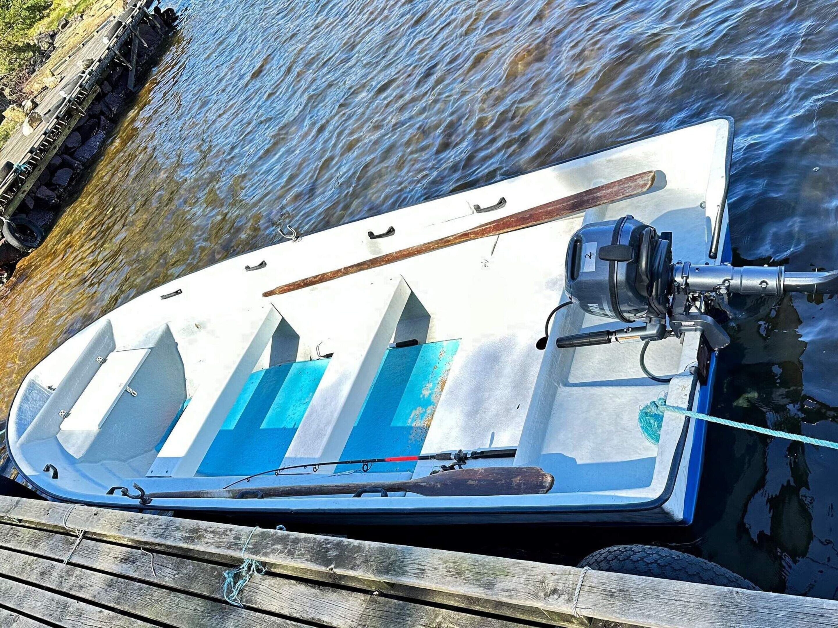 A small boat docked at a wooden pier.