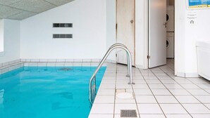 A swimming pool with a metal ladder, a door leading to a laundry area, and a ceiling with recessed lighting. - 10 Person Holiday Home in Ebeltoft-by Traum (Ebeltoft)