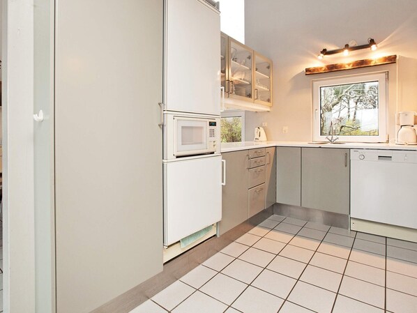 Una cocina equipada con microondas, horno y armarios.