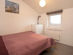 A bedroom with a bed, a dresser, a window, and a painting on the wall. - 10 Person Holiday Home in Ebeltoft-by Traum (Ebeltoft)