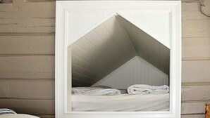 A framed picture of a room with a sloped ceiling, a bed with white bedding, and a wooden headboard. - Holiday Home in Tornes I Romsdal (Hustadvika)
