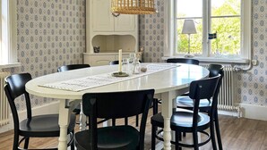 A dining table with six chairs, a candle, and a decorative item on the table. - Holiday Home in Vargön (Västra Tunhem)
