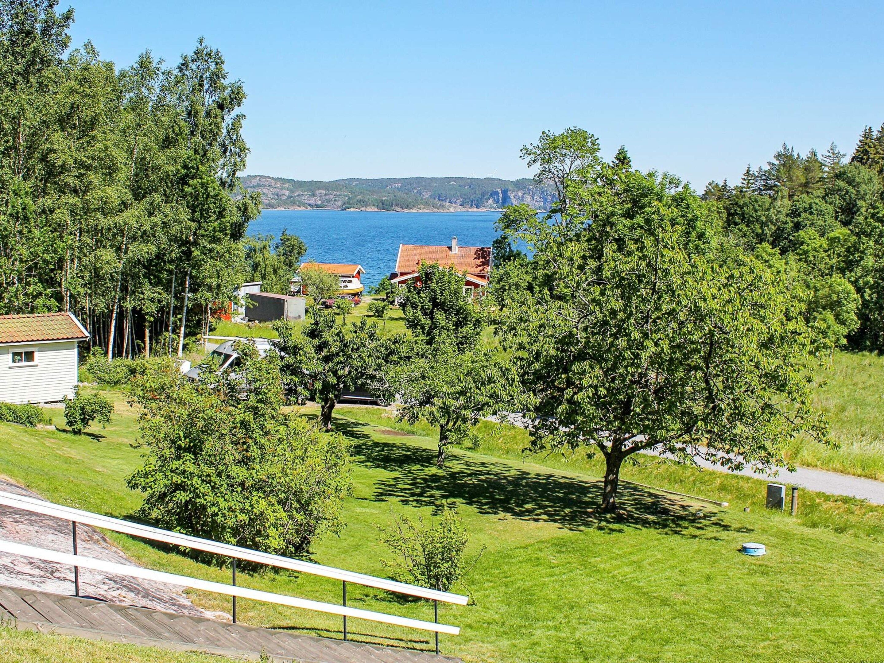 Área residencial com casas, um campo gramado e um corpo d'água ao fundo.