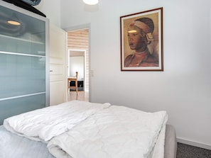 A bedroom with a bed, a framed painting on the wall, and a door leading to another room. - 6 Person Holiday Home in Juelsminde-by Traum (Juelsminde)