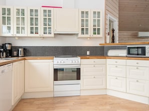 A kitchen with white cabinetry, a black tiled backsplash, a wooden countertop, a white stove, and a microwave. - 6 Person Holiday Home in Juelsminde-by Traum (Juelsminde)