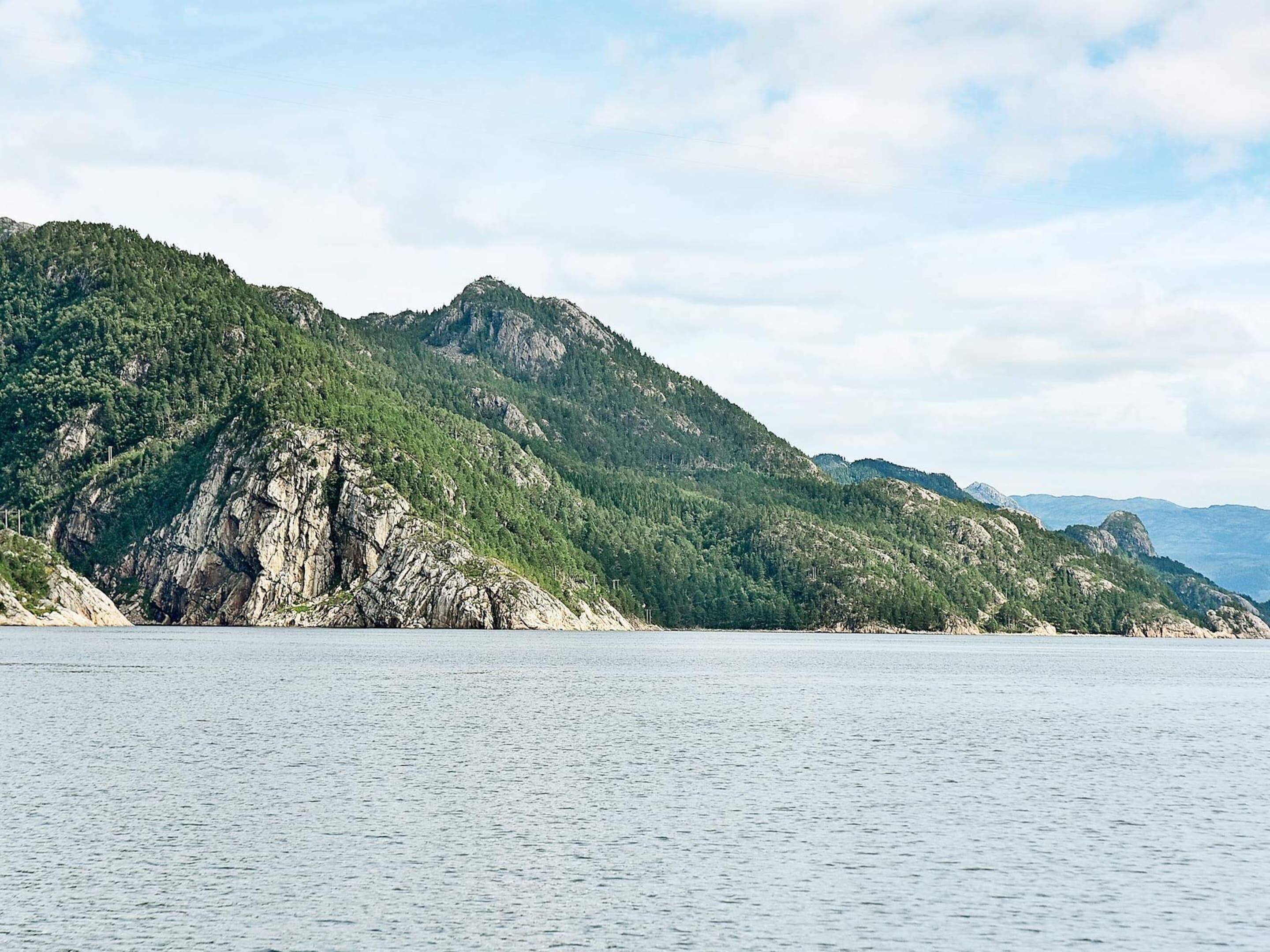 A coastal landscape with rocky cliffs and a calm sea.