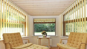 A room with two yellow cushioned chairs and a small table with a vase of flowers. - Luxurious Holiday Home Near Hals With Whirlpool (Hals)