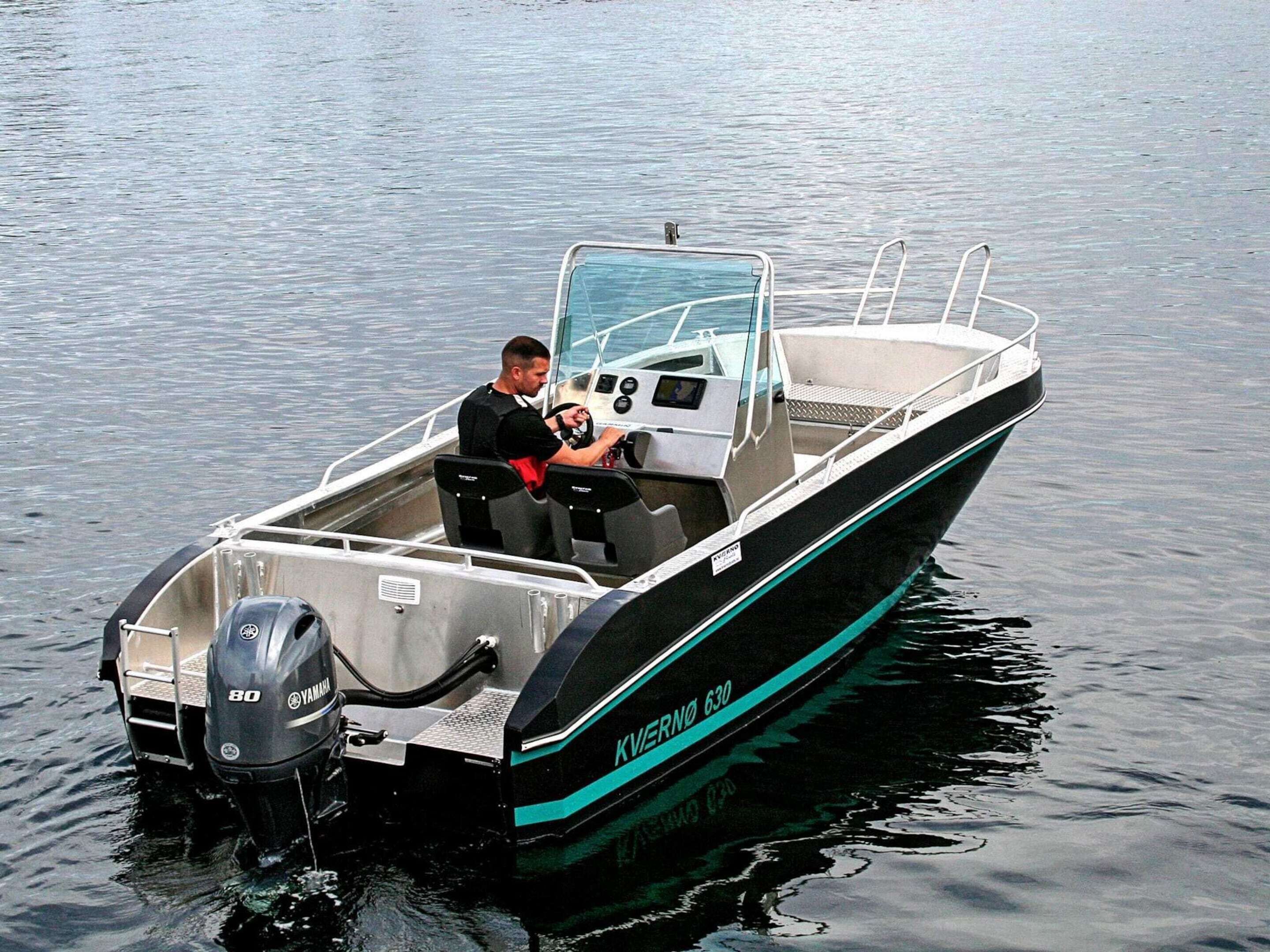 Un petit bateau à moteur équipé d’un moteur hors-bord Yamaha, d’un volant et d’une personne assise au poste de pilotage.