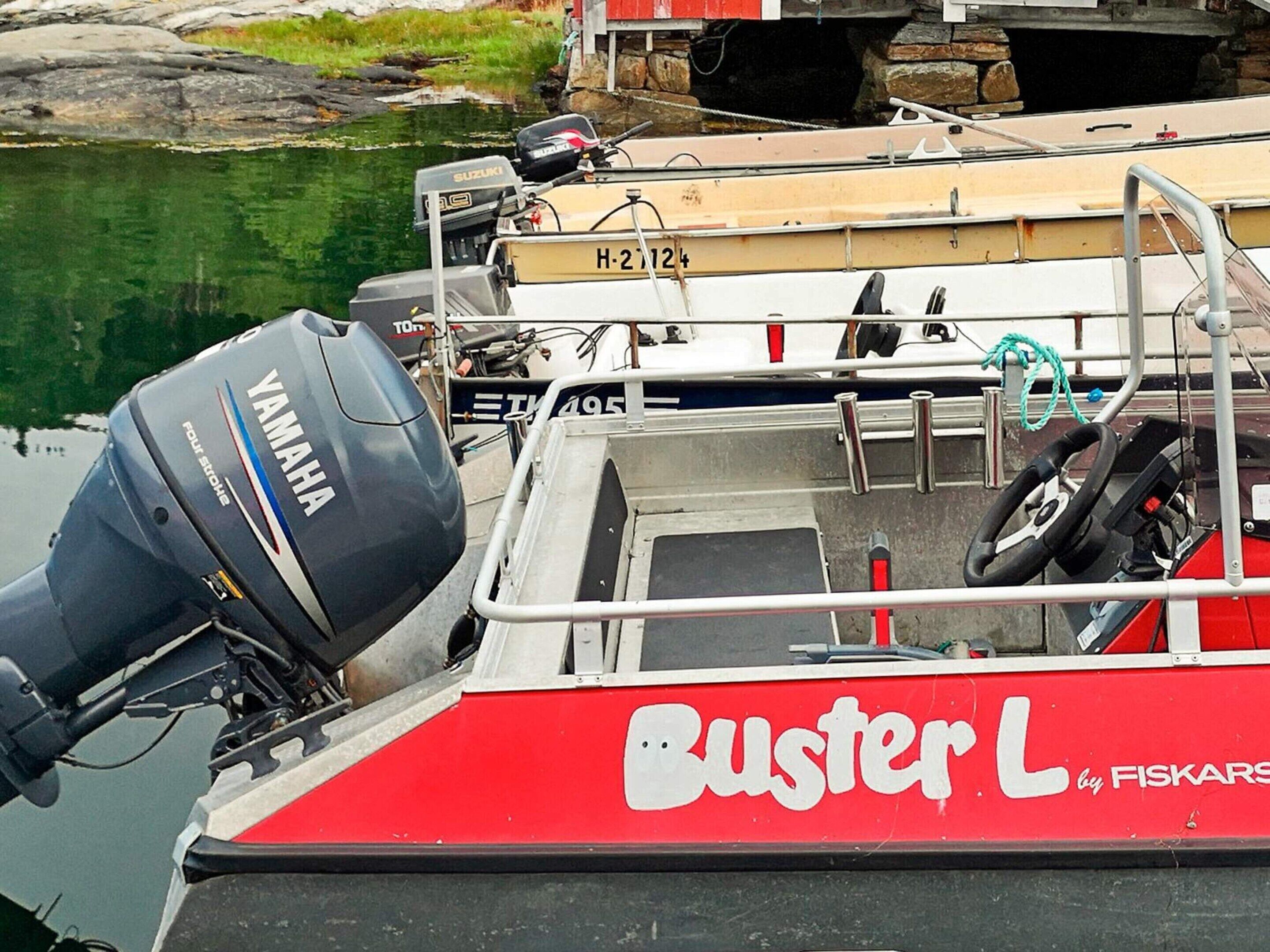 En båt vid namn ”Buster L” med en Yamaha-utombordsmotor låg förtöjd i en småbåtshamn tillsammans med andra båtar.