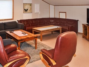 A living room with a brown leather sofa, a wooden coffee table, and two leather armchairs. - 12 Person Holiday Home in Oksvoll (Orland)