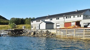 Un edificio sul lungomare con un molo, una barca e una pila di arance.