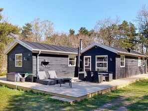 A two-story cabin with a deck, outdoor seating, and a chimney. - Attractive Holiday Home with Whirlpool near Hadsund (Hadsund)