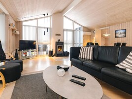 Una sala de estar moderna con chimenea, un sofá, una mesa de centro y un televisor.