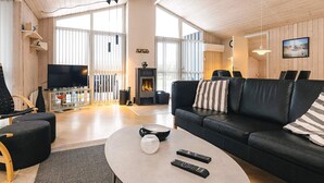A modern living room with a fireplace, a sofa, a coffee table, and a television.