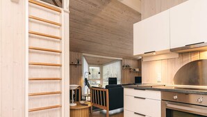 A modern kitchen with wooden cabinets, a stainless steel range hood, and a built-in oven.