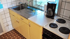 Een keuken met een dubbele spoelbak, een koffiezetapparaat en een fornuis.