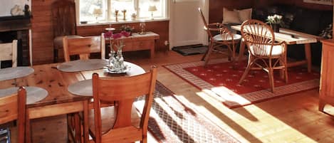 A cozy dining area with wooden furniture, a table with chairs, and a window with curtains.