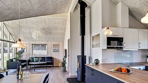 A modern kitchen with dark cabinets, a wooden countertop, and a built-in stove. - Holiday Home in Kappeln (Kappeln)