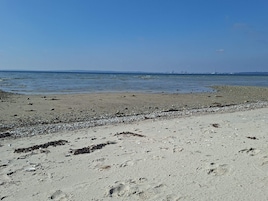 Una playa con costa rocosa y agua tranquila.