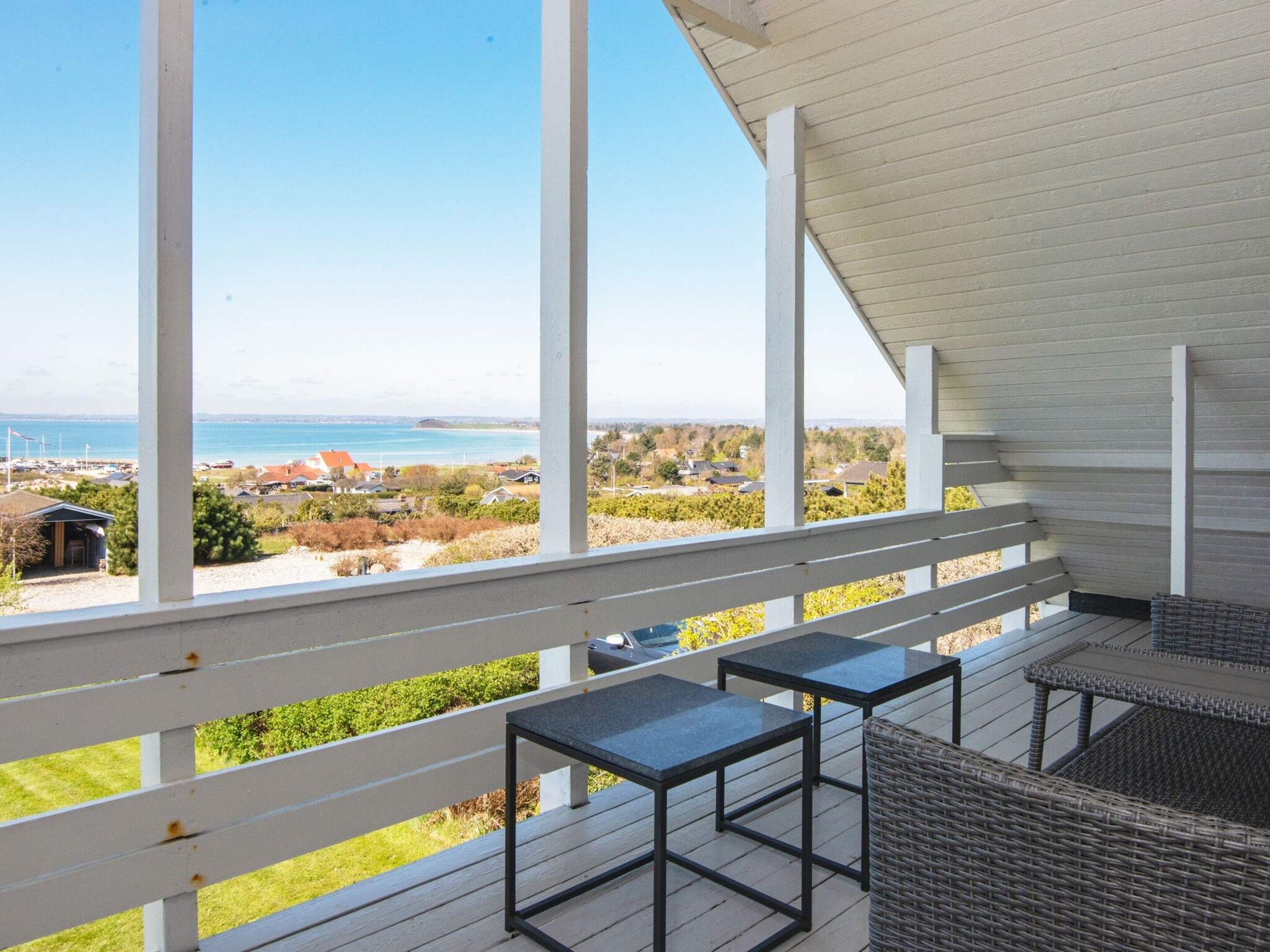 Un balcon avec vue sur la mer et sur un quartier résidentiel.